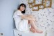 A woman sitting on top of a white dresser.