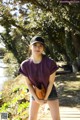 A young woman wearing a baseball cap and holding a baseball glove.