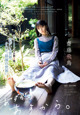 A woman sitting on a wooden floor next to a bowl of water.