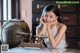 A woman sitting at a table with a scale in front of her.