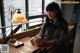 A woman sitting at a table with a cup of coffee.